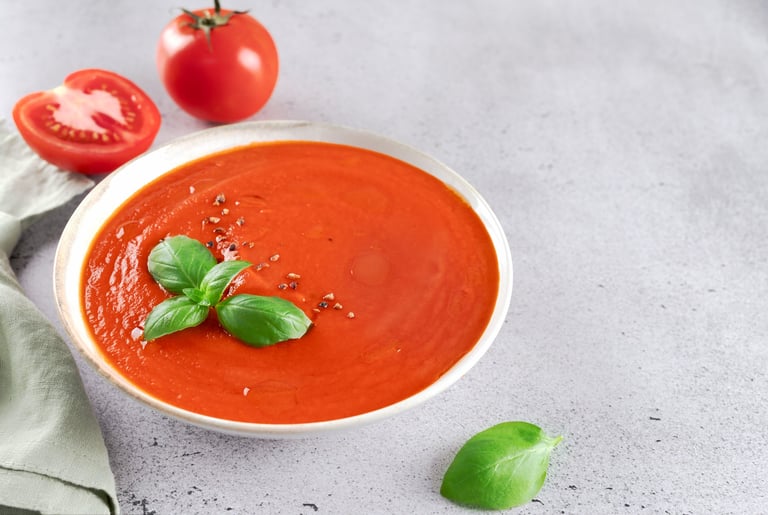 Fresh tomato cream soup with basil leaves, cherry tomatoes on gray background. Vegetarian food. High quality photo